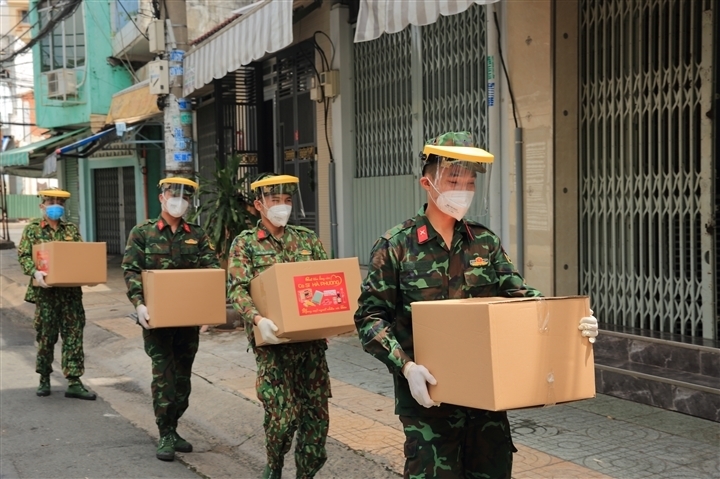  
Các chiến sĩ giúp Hà Phương mang thùng quà đến tận tay người dân. (Ảnh: FBNV)