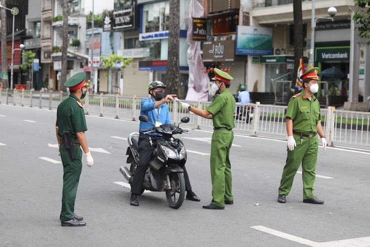  
Lực lượng chức năng tiến hành kiểm tra giấy tờ của người đi đường. (Ảnh: Doanh Nhân Sài Gòn)