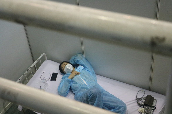  
Nhân viên y tế tranh thủ nghỉ ngơi sau ca làm việc của mình. (Ảnh: Tuổi Trẻ)