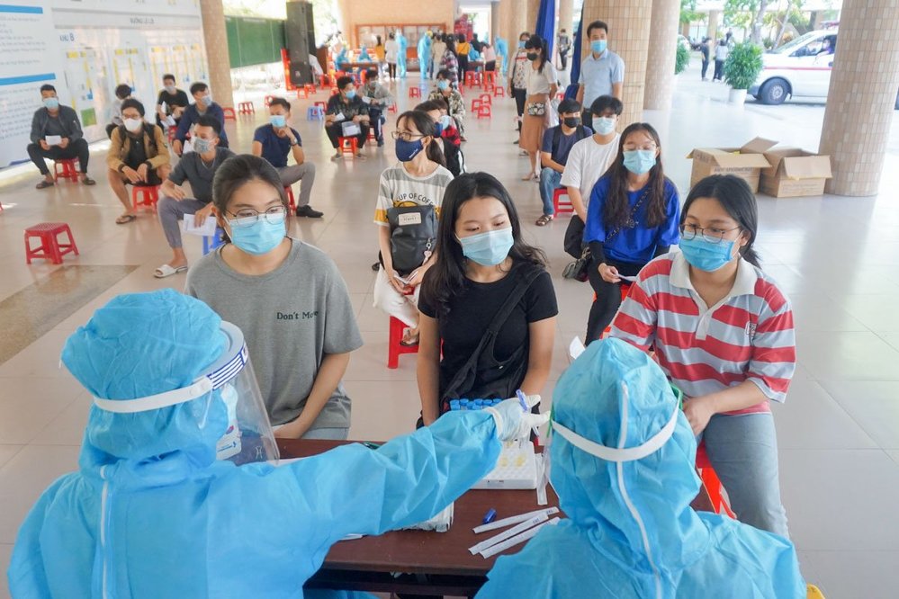  Các em học sinh đang được nhân viên y tế lấy mẫu xét nghiệm lần lượt. (Ảnh: Sài Gòn Giải Phóng)