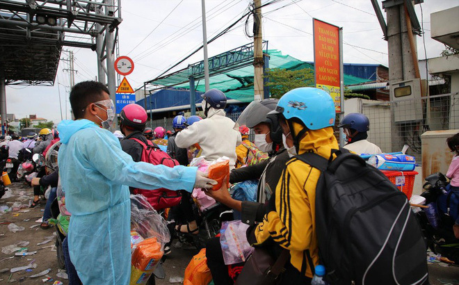  Lực lượng chức năng tặng áo mưa, đồ ăn cho bà con đi đường. (Ảnh: VOV)