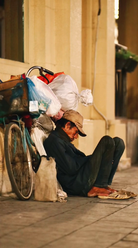 Cụ ông nằm ngủ gục giữa hè phố. (Ảnh: Chụp màn hình)