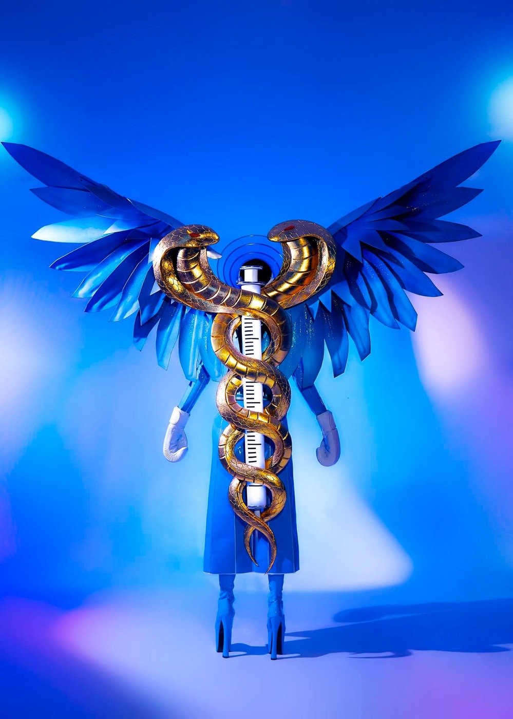  
Phía sau bộ trang phục là đôi rắn mạ vàng quấn quanh ống tiêm Vaccine tạo thành biểu tượng của ngành y. (Ảnh: FBNV) - Tin sao Viet - Tin tuc sao Viet - Scandal sao Viet - Tin tuc cua Sao - Tin cua Sao