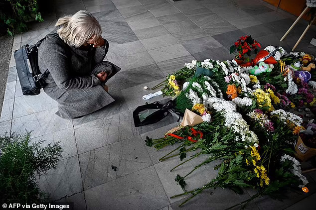  
Một người phụ nữ đến đưa hoa tưởng niệm các nạn nhân xấu số. (Ảnh: AFP)