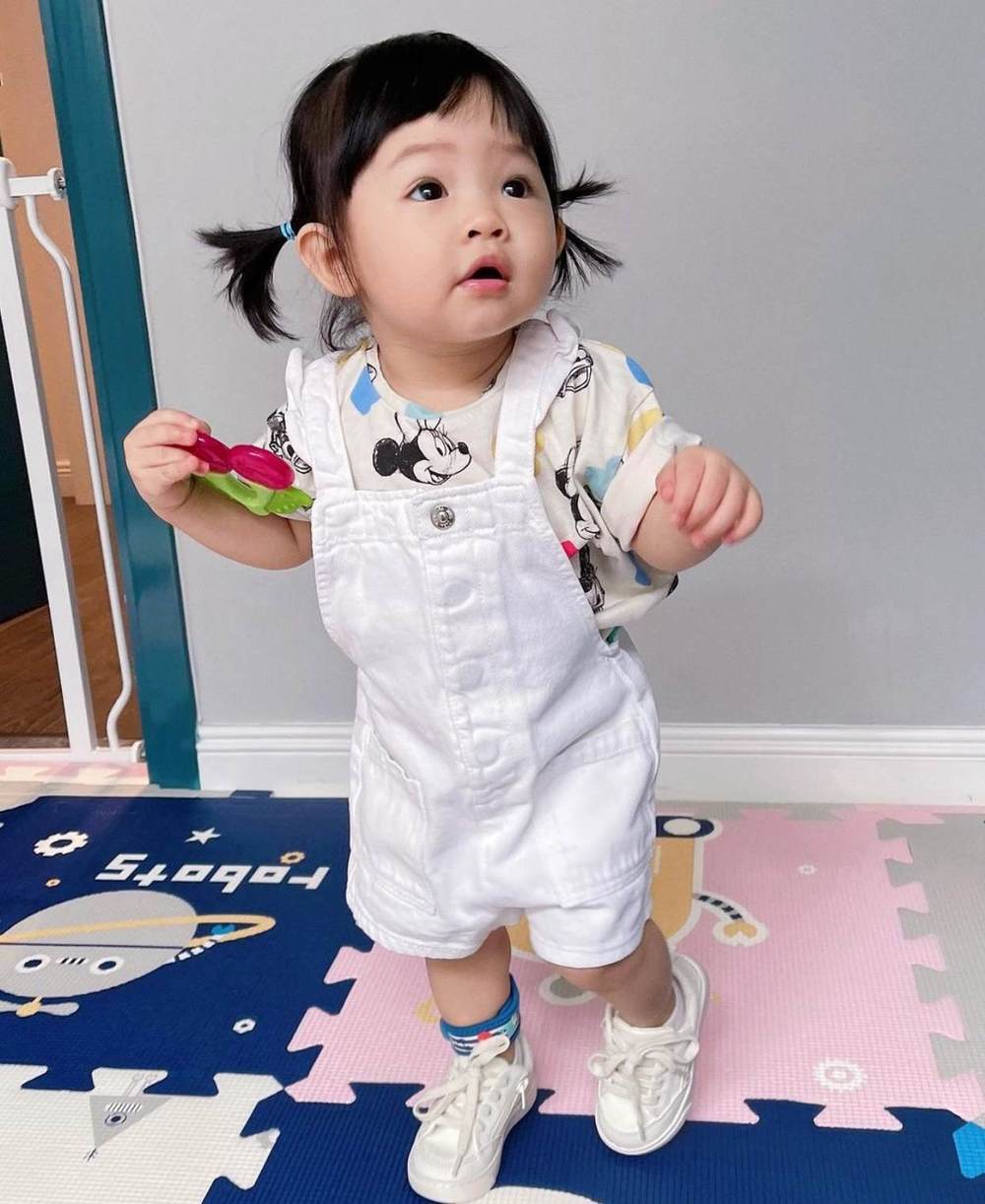  
Suchin được mẹ phối yếm trắng với áo họa tiết Mickey dễ thương. (Ảnh: Instagram suchin_baby)
