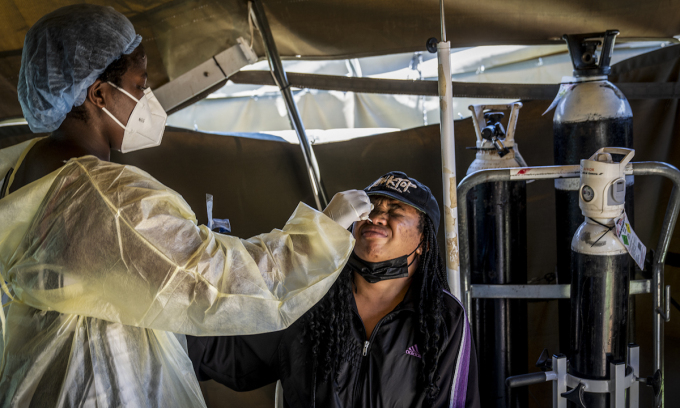  
Nhân viên y tế lấy mẫu xét nghiệm cho các công nhân gần Johannesburg, Nam Phi. (Ảnh: AP)