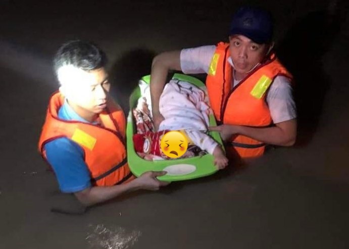  
Lực lượng cứu hộ đưa em bé sơ sinh vượt dòng nước lũ trong đêm. (Ảnh: Báo Chính phủ)