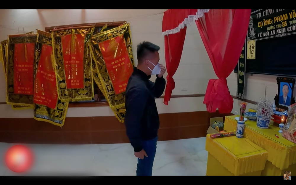  
Anh chàng bật khóc trước bàn thờ ông. (Ảnh: YouTube Quang Linh Vlogs)