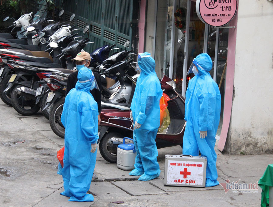  
Nhân viên trạm y tế tới từng nhà F0 theo dõi tình hình sức khoẻ. (Ảnh: VietNamNet)