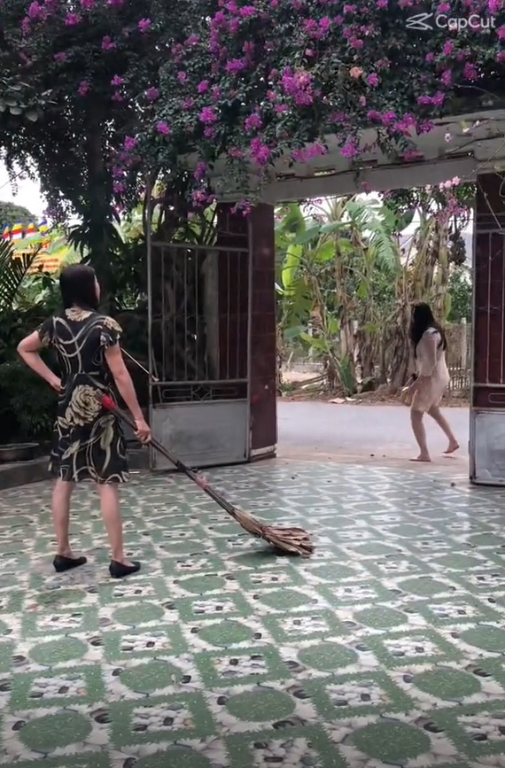  Người mẹ cầm chổi "quét" gái cưng ra tận ngoài cổng. (Ảnh: Chụp màn hình video TikTok N.)