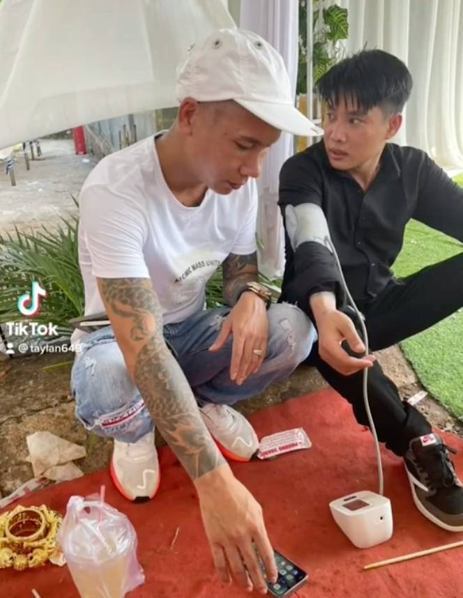  
Chú rể phải bỏ đống kiềng vàng sang một bên để đo huyết áp. (Ảnh: TikTok taylan649)