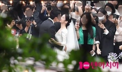  
Hình ảnh nữ diễn viên cùng chồng hôn nhau lãng mạn trong hôn lễ. (Ảnh: 10asia)