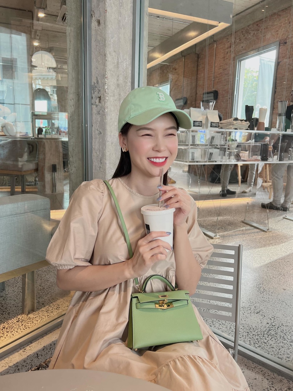 Nữ MC xinh đẹp xuống phố với chiếc đầm màu beige và túi xách Hermes màu xanh cùng màu với mũ lưỡi trai cá tính. (Ảnh: FB Sam)