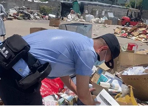  Giữa trời nắng nóng 40 độ C, cảnh sát vẫn chăm chỉ lật từng hộp giấy trong đống rác để tìm lại tiền giúp vợ chồng bà Hứa. (Ảnh: GMW)