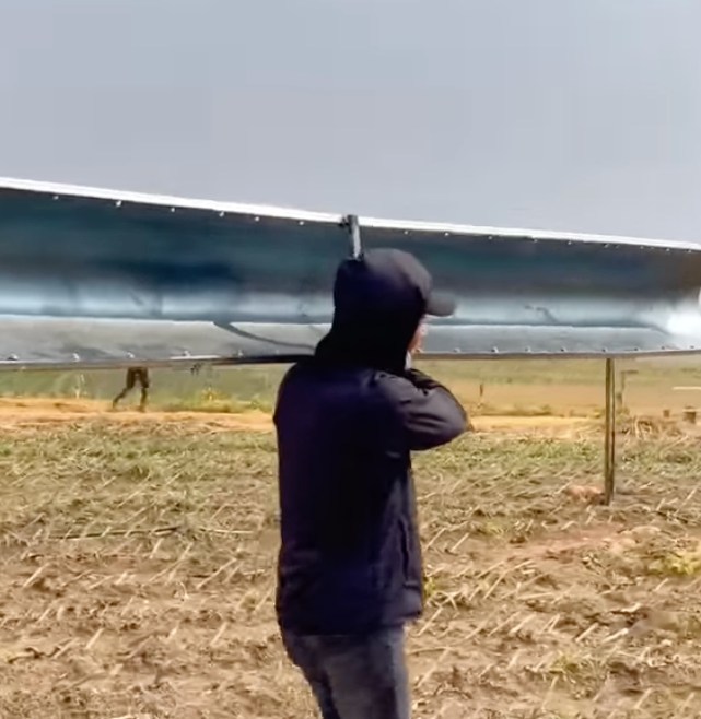  Sau khi hoàn thành chiếc máng, anh chàng tự mình bê ra chuồng để lắp đặt. (Ảnh: YouTube Quang Linh Vlogs - Cuộc Sống ở Châu Phi)