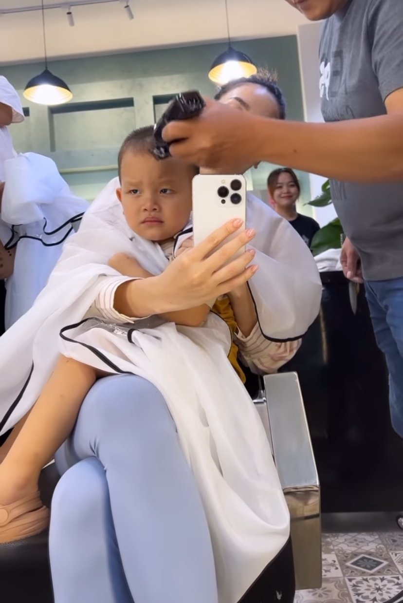 Cậu Ú nhà Hà Hồ bày tỏ sự không hài lòng dù được mẹ dẫn đi cắt tóc ở tiệm xịn sò. (Ảnh: Chụp màn hình Instagram henrylisaleon)