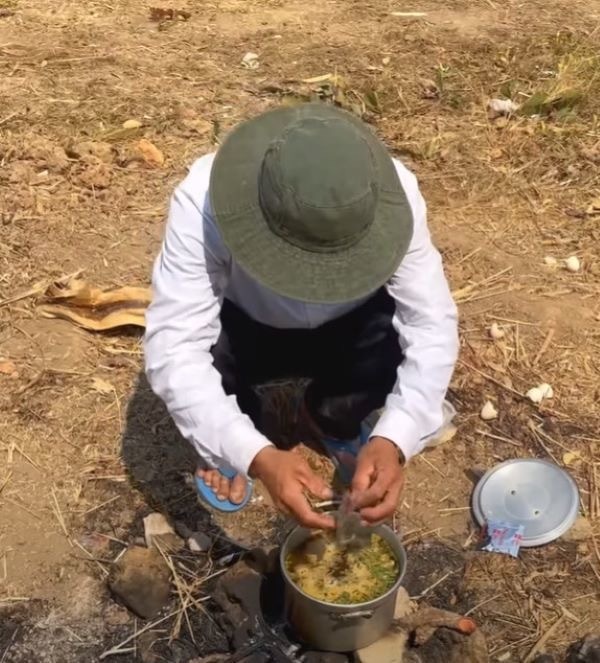  
Quang Linh nấu mì tôm ăn ngay tại ruộng khiến nhiều người ngỡ ngàng bởi sự giản dị của chàng trai xứ Nghệ. (Ảnh: YouTube Quang Linh Vlogs)