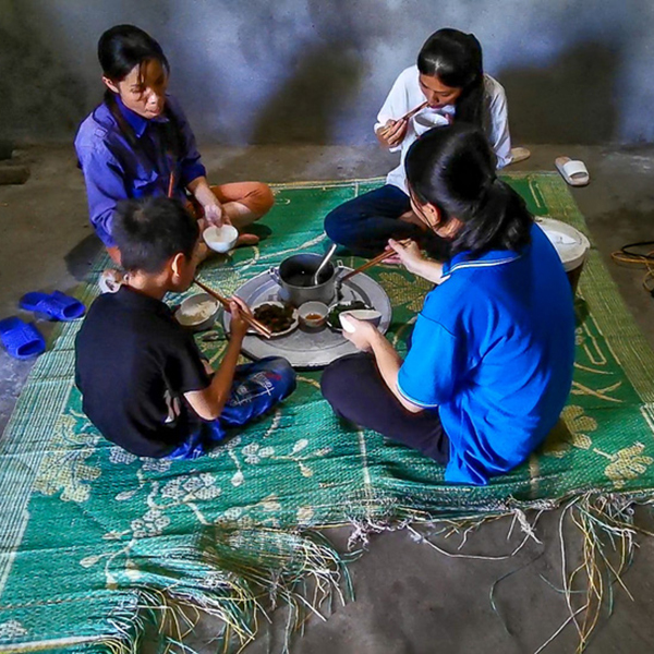  
4 mẹ con ngồi ăn cơm dưới manh chiếu rách khiến ai nấy đều xót xa. (Ảnh: Tuổi trẻ online)