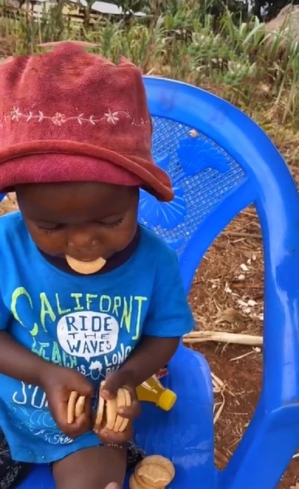  Lôi Con chọn bánh lành lặn đưa cho chú Linh. (Ảnh: YouTube Quang Linh Vlogs - Cuộc sống châu Phi)