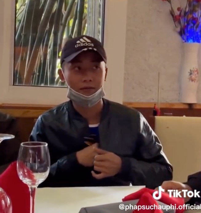  Quang Linh giả vờ giấu bộ dụng cụ ăn mang về. (Ảnh: Chụp màn hình TikTok Pháp sư châu Phi)