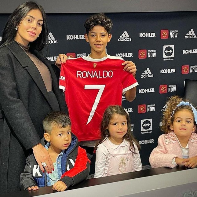  
Cristiano Jr cầm trên tay chiếc áo số 7 đứng bên cạnh bạn gái của bố và các em trong gia đình ngày ra mắt CLB mới. (Ảnh: IG Cristianojunior7)