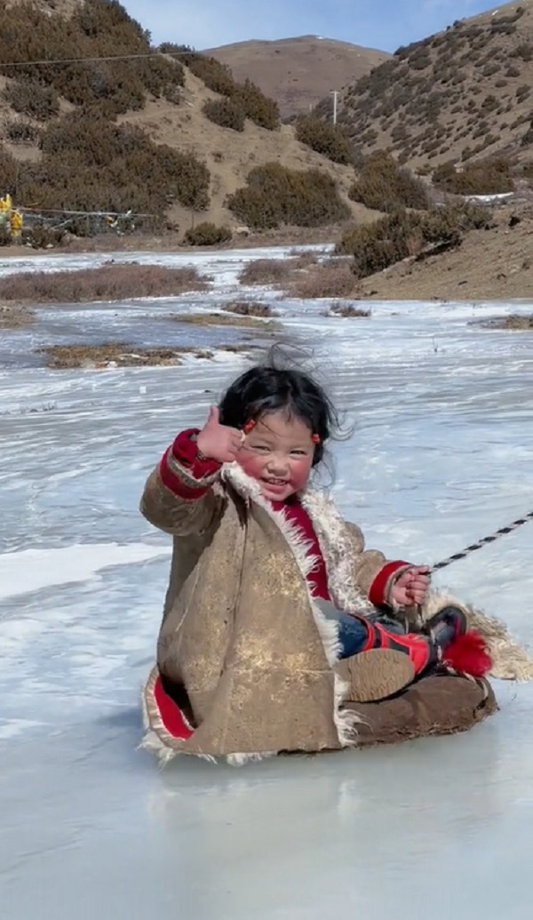  Cô bé hào hứng vui đùa trên băng tuyết. (Ảnh: Cắt từ clip Douyin)
