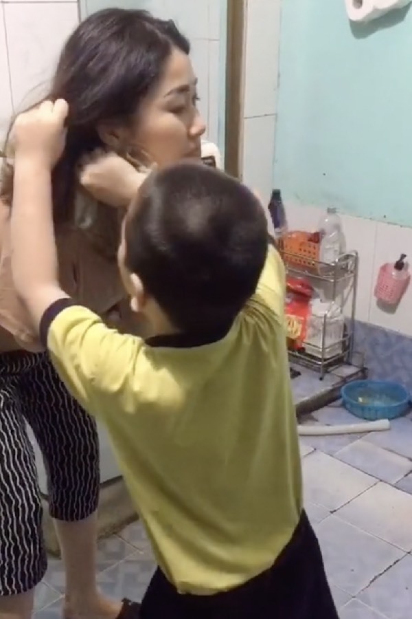  
Cậu bé thuần thục vén tóc của mẹ lên để lau mặt cho sạch. (Ảnh: TikTok N.S.A)