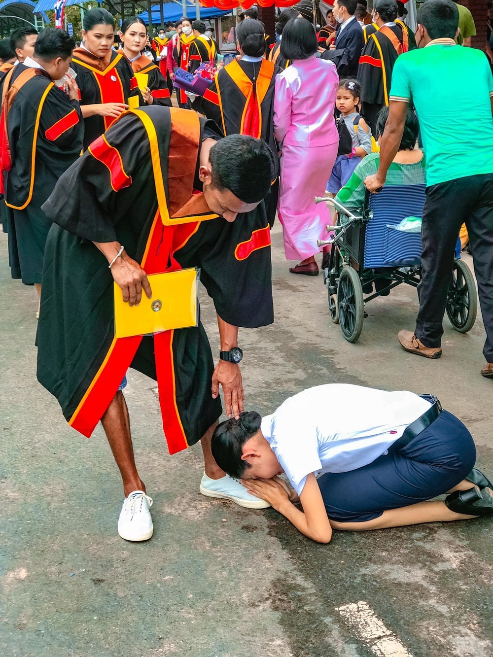  
Em gái quỳ gối để cảm ơn anh trai đã hy sinh bản thân để cô được đi học tiếp. (Ảnh: FB Ying Chanita)