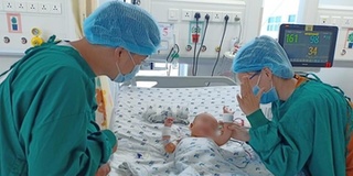 Hình ảnh 2 bé song sinh nô đùa cùng bố mẹ, hướng mắt nhìn nhau