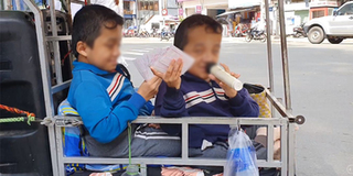 Cặp song sinh bị chứng xương thủy tinh, theo mẹ bán vé số khắp Sài Gòn